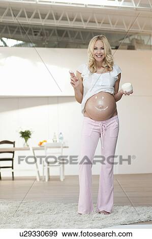 Pregnant woman creaming belly View Large Photo Image Stock Photo - Pregnant woman creaming belly. Fotosearch