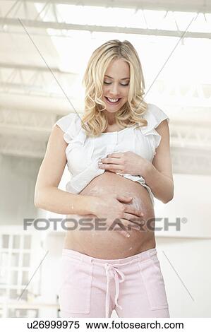 Pregnant woman creaming belly View Large Photo Image Stock Photography - Pregnant woman creaming belly. Fotosearch