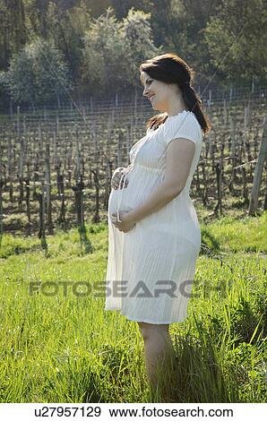 Stock Photo - Pregnant woman holding bump. Fotosearch