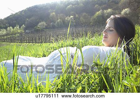 Pregnant woman in long spring grass View Large Photo Image Stock Image - Pregnant woman in long spring grass. Fotosearch