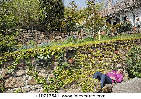 Stock Image - Pregnant woman relaxing in spring garden. Fotosearch