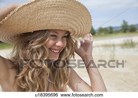 Stock Photograph - Pretty woman in straw hat laughing. Fotosearch