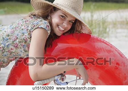 Stock Photo - Pretty woman resting on buoyancy ring. Fotosearch