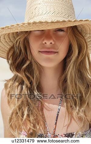 Stock Photo - Pretty women in straw hat in the sun. Fotosearch