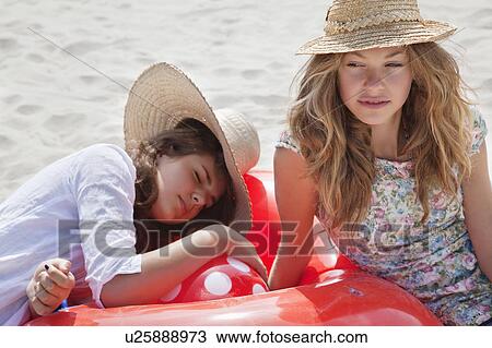 Stock Image - Pretty women relaxing on the beach. Fotosearch