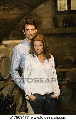 Proud couple standing in wine cellar View Large Photo Image Stock Photo - Proud couple standing in wine cellar. Fotosearch