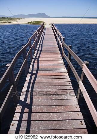 Stock Image - Raised boardwalk across sea. Fotosearch