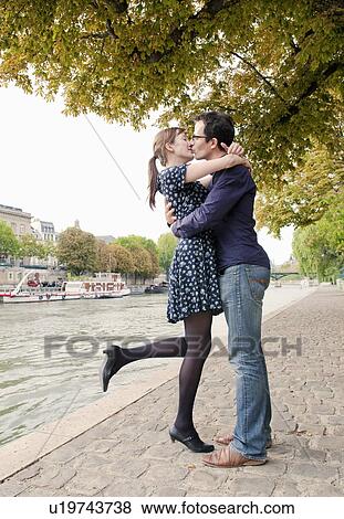 Romantic couple kiss by river Seine View Large Photo Image Stock Photo - Romantic couple kiss by river Seine. Fotosearch