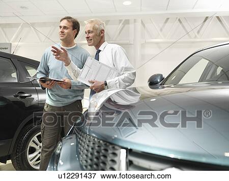 Salesman and customer in car dealership View Large Photo Image Stock Photo - Salesman and customer in car dealership. Fotosearch