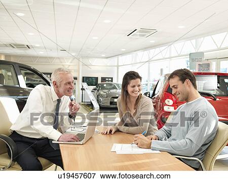 Salesman and customers in car dealership View Large Photo Image Stock Photo - Salesman and customers in car dealership. Fotosearch
