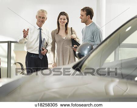 Salesman and customers in car dealership View Large Photo Image Stock Photography - Salesman and customers in car dealership. Fotosearch