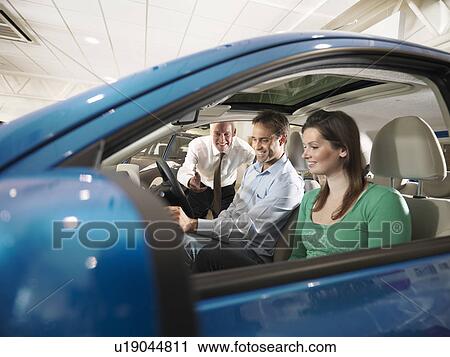 Salesman shows customers a car View Large Photo Image Stock Image - Salesman shows customers a car. Fotosearch