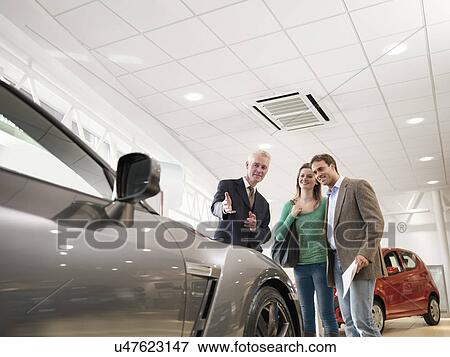 Salesman shows customers car View Large Photo Image Stock Photo - Salesman shows customers car. Fotosearch