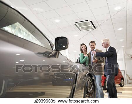 Salesman shows customers car View Large Photo Image Stock Photography - Salesman shows customers car. Fotosearch