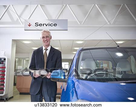 Salesman with car in car dealership View Large Photo Image Stock Image - Salesman with car in car dealership. Fotosearch