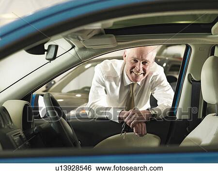 Salesman with car in car dealership View Large Photo Image Stock Photograph - Salesman with car in car dealership. Fotosearch