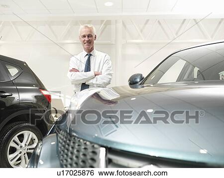 Salesman with car in car dealership View Large Photo Image Stock Photograph - Salesman with car in car dealership. Fotosearch