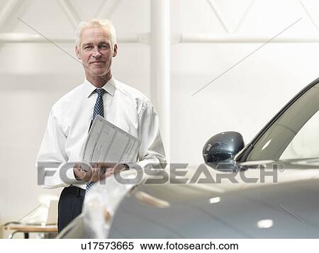 Salesman with car in car dealership View Large Photo Image Stock Photography - Salesman with car in car dealership. Fotosearch