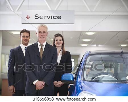 Salespeople with car in car dealership View Large Photo Image Stock Photo - Salespeople with car in car dealership. Fotosearch
