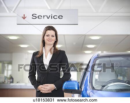 Saleswoman with car in car dealership View Large Photo Image Stock Image - Saleswoman with car in car dealership. Fotosearch