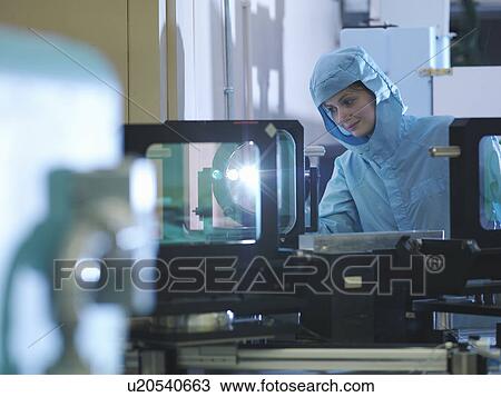 Stock Image - Scientist checking laser filter. Fotosearch