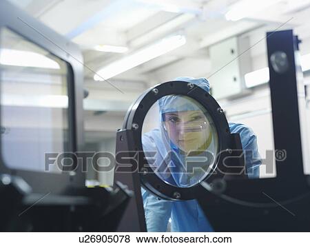 Stock Photo - Scientist checking laser filter. Fotosearch