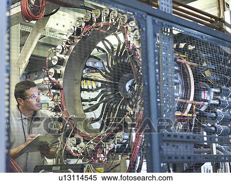 Scientist inspects particle accelerator View Large Photo Image Stock Photography - Scientist inspects particle accelerator. Fotosearch