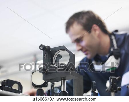 Scientist setting up laser path View Large Photo Image Stock Photo - Scientist setting up laser path. Fotosearch