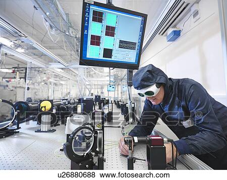 Stock Photo - Scientist setting up laser path. Fotosearch