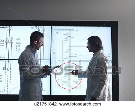 Stock Image - Scientist with diagrams on screen. Fotosearch