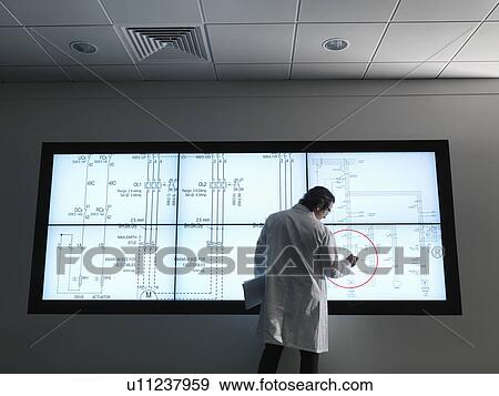 Stock Photo - Scientist with diagrams on screen. Fotosearch