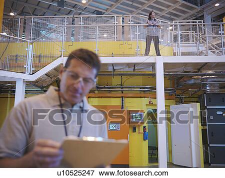 Stock Photo - Scientists in particle accelerator hall. Fotosearch