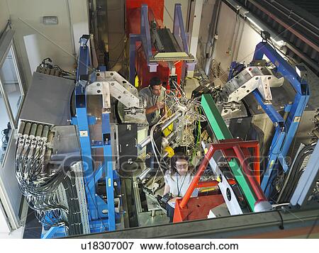 Stock Photo - Scientists inspect particle accelerator. Fotosearch