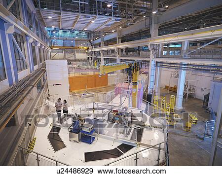 Stock Photo - Scientists on particle accelerator. Fotosearch