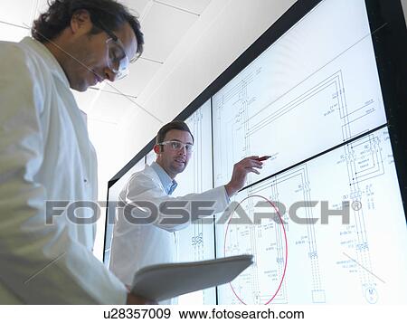 Stock Photo - Scientists with diagrams on screen. Fotosearch