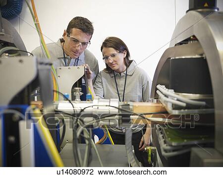 Stock Image - Scientists with particle accelerator. Fotosearch