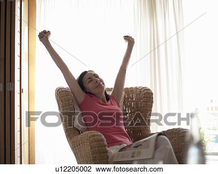 Seated woman, stretching arms View Large Photo Image Stock Image - Seated woman, stretching arms. Fotosearch