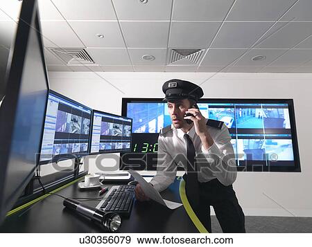 Stock Photo - Security guard in control room. Fotosearch