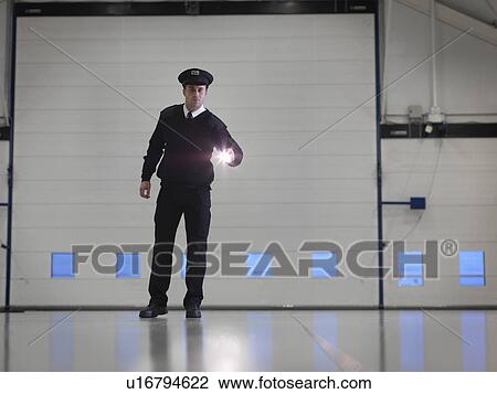 Security guard with torch in warehouse View Large Photo Image Stock Image - Security guard with torch in warehouse. Fotosearch