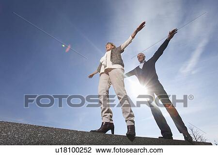 Senior couple balancing along a wall View Large Photo Image Stock Image - Senior couple balancing along a wall. Fotosearch
