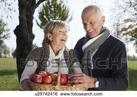 Stock Photograph - Senior couple with basket of apples. Fotosearch