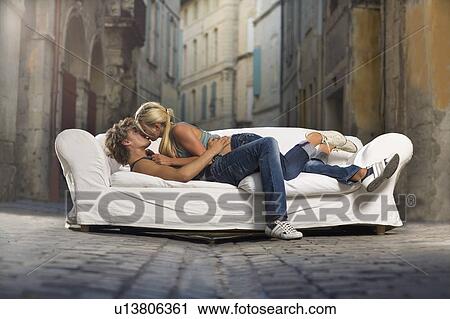 Stock Image - Sexy couple kiss on couch in street. Fotosearch