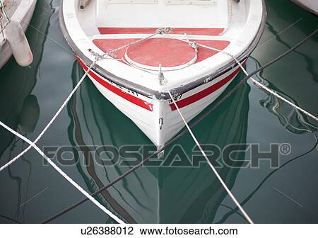 Stock Image - Small boat moored in harbour. Fotosearch