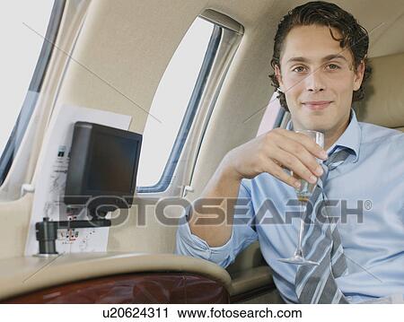 Smiling businessman in private jet View Large Photo Image Stock Image - Smiling businessman in private jet. Fotosearch
