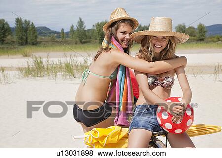Stock Photo - Smiling women together on the beach. Fotosearch