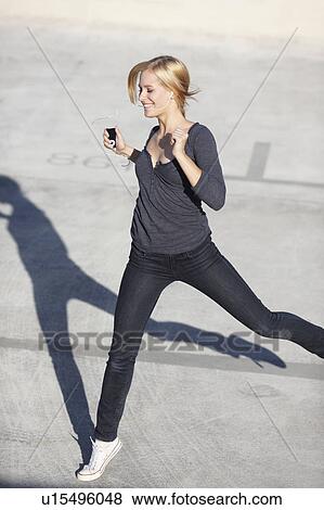 Smiling women with ipod jumping View Large Photo Image Stock Photo - Smiling women with ipod jumping. Fotosearch