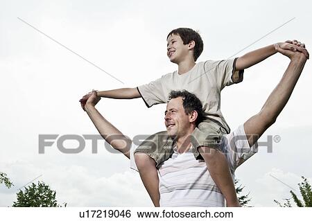 Son on father's shoulders View Large Photo Image Stock Photograph - Son on father's shoulders. Fotosearch