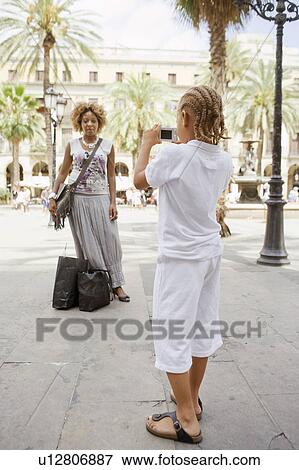 Stock Photo - Son taking picture of mother. Fotosearch