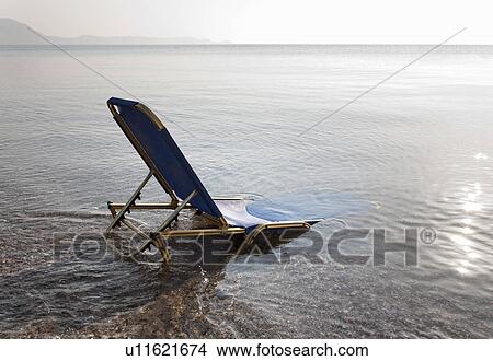 Sunlounger semi-submerged in sea View Large Photo Image Picture - Sunlounger semi-submerged in sea. Fotosearch
