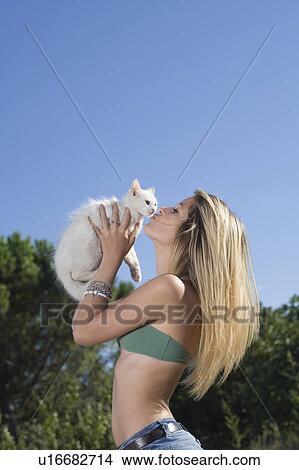 Picture - Teen girl kisses kitten outside. Fotosearch